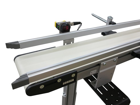 2200 Series conveyor equipped with photo-eyes, a retractable end stop and a pusher